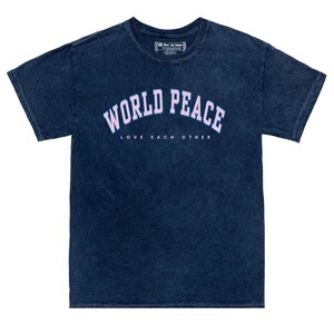 K&ouml;nnte beinhalten: Marineblaues T-Shirt mit dem Schriftzug "WORLD PEACE" in hellrosa Bogenform. Darunter sind die Worte "LOVE EACH OTHER" in Wei&szlig; gedruckt. Das T-Shirt hat einen verwaschenen Vintage-Look, mit Rundhalsausschnitt und kurzen &Auml;rmeln.