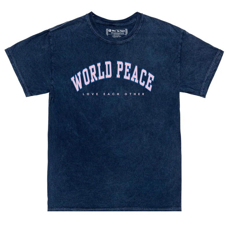 K&ouml;nnte beinhalten: Marineblaues T-Shirt mit dem Schriftzug "WORLD PEACE" in hellrosa Bogenform. Darunter sind die Worte "LOVE EACH OTHER" in Wei&szlig; gedruckt. Das T-Shirt hat einen verwaschenen Vintage-Look, mit Rundhalsausschnitt und kurzen &Auml;rmeln.