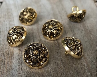 May include: Six gold-toned buttons with intricate floral designs. The buttons are round and have a raised, domed shape.
