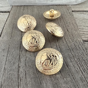 May include: Five gold-tone buttons with an embossed elephant design. The buttons are round and have a raised edge.