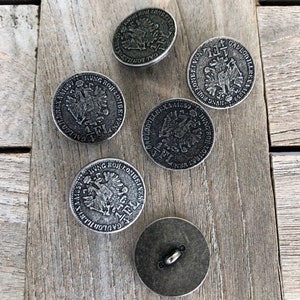 May include: Five silver-toned buttons with raised designs. The buttons feature a two-headed eagle with the text "GALLON" and "HUNG BOR LOMBEI VEN" around the eagle. One button has the text "FL" on it.