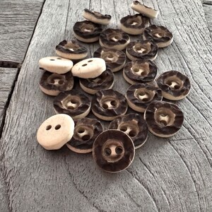 Peut inclure: Un ensemble de boutons &agrave; deux trous de couleur marron et blanche avec une surface textur&eacute;e.
