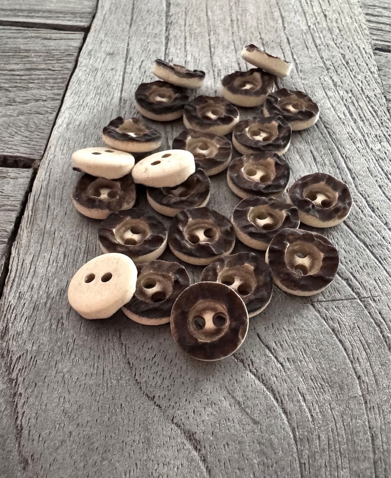 Peut inclure: Un ensemble de boutons &agrave; deux trous de couleur marron et blanche avec une surface textur&eacute;e.