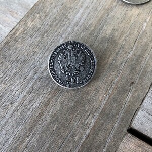 May include: A silver-toned button with a raised design of a double-headed eagle and the text "1 FL" in the center.
