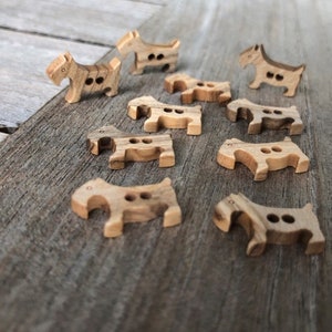 Peut inclure: Une collection de boutons en bois en forme de chiens. Les boutons sont de couleur brun clair avec un grain de bois brun fonc&eacute;.