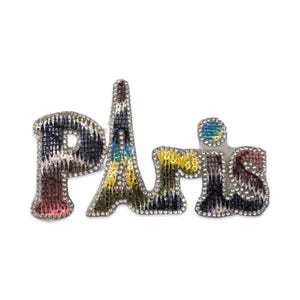 May include: A colorful, sparkly, and glittery word art piece that says "Paris" in a stylized font. The letters are made of a fabric-like material and are covered in rhinestones.