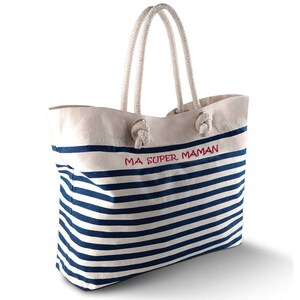 May include: A canvas tote bag with navy blue and white horizontal stripes. The bag has a white top with the red text "MA SUPER MAMAN". It features rope handles and is suitable for carrying items.