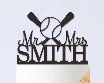 May include: Black and white baseball themed wedding cake topper with the text "Mr. & Mrs. SMITH".