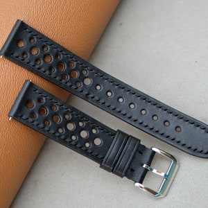 May include: Two black leather watch straps with a perforated design. The straps have a silver buckle.
