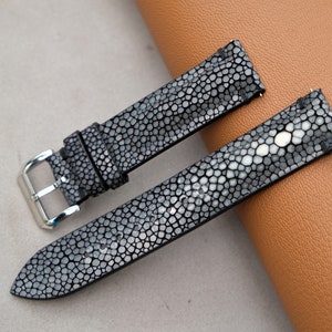 May include: Two black leather watch straps with a textured, patterned surface. The straps have silver buckles.