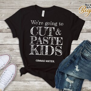 Puede incluir: Camiseta negra con texto blanco que dice "We're going to CUT & PASTE KIDS, COMMAS MATTER."