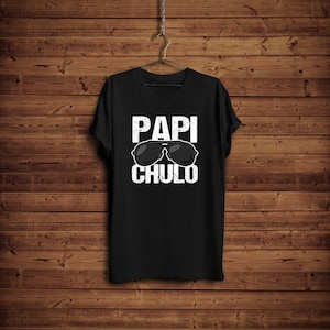 May include: Black t-shirt with white text that reads "Papi Chulo" and a pair of sunglasses.