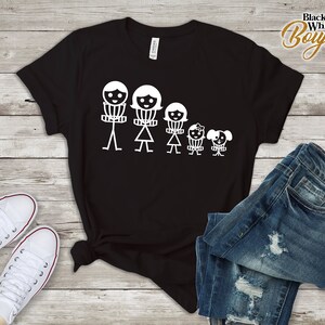 K&ouml;nnte beinhalten: Schwarzes T-Shirt mit einer wei&szlig;en Grafik einer Familie aus Strichm&auml;nnchen, die Frisbees halten. Die Familie besteht aus einem Vater, einer Mutter, zwei Kindern und einem Hund.