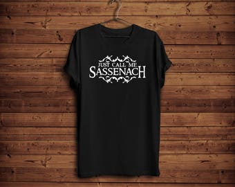 May include: Black t-shirt with white text that reads "Just Call Me Sassenach" with a decorative design.