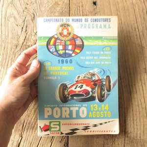 May include: A vintage programme for the 1960 IX Grande Premio de Portugal Formula 1 race in Porto, Portugal. The programme features a red race car with the number 14 on the side, and the text "13 & 14 Agosto" on a blue background.