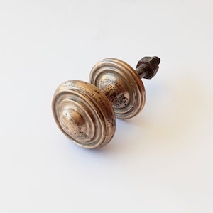 May include: A brass door knob with a round, fluted design. The knob has a screw-on attachment.