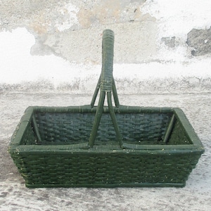 May include: A dark green woven basket with a handle. The basket is made of natural materials and has a rectangular shape.
