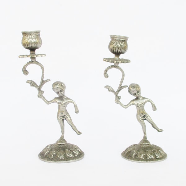 Vintage boy holding a flower shaped chromed brass pair of candle holders candlesticks. Home decor. Spaces decor. Paire de bougeoirs