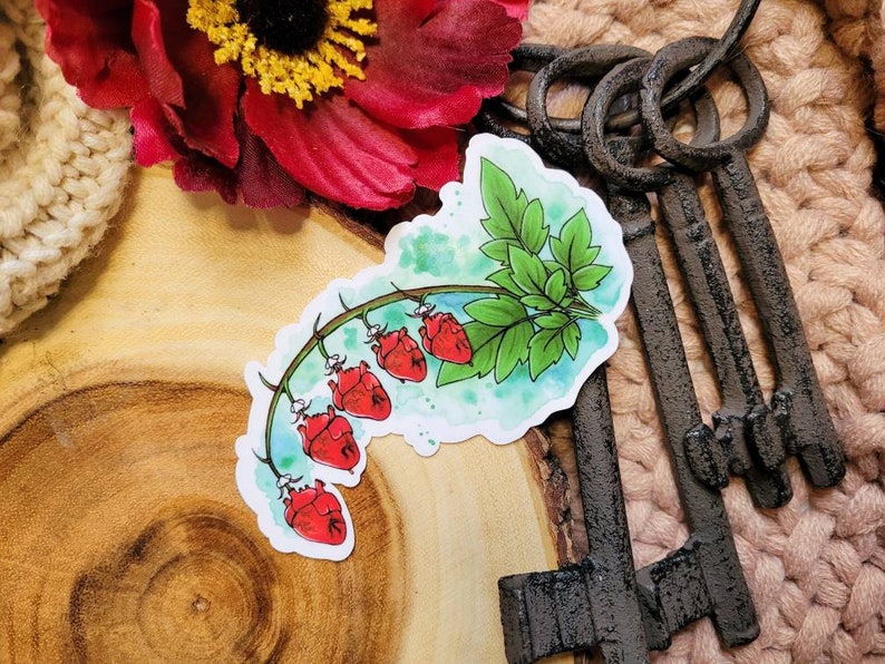 May include: A sticker featuring a watercolor illustration of a vine with five red hearts hanging from it. The vine has green leaves and is set against a light blue background.