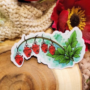 May include: A sticker featuring a watercolor illustration of a vine with five red hearts hanging from it. The vine has green leaves and is set against a blue and white watercolor background.