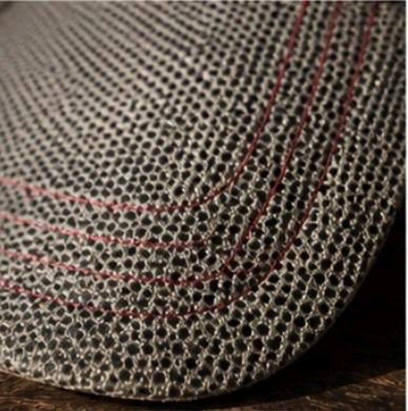 May include: Close-up of a gray, textured hat with a perforated design. The hat features red stitching along the curved brim. The hat's material appears to be breathable, with a honeycomb-like pattern. The hat is likely for sun protection.