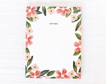 May include: A white notepad with a floral border. The border features pink and green flowers. The notepad has the word "NOTES" printed at the top.