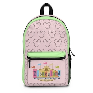 May include: A pink and green backpack with a black zipper and a white outline of Mickey Mouse ears repeated on the front and back. The front pocket has a colorful Disneyland logo with the text "The Happiest Place On Earth" and "Est. 1955".