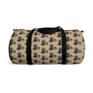 Puede incluir: Una bolsa de lona marr&oacute;n y negra con un patr&oacute;n repetido de un peque&ntilde;o personaje alien&iacute;gena verde y un personaje mandaloriano. La bolsa tiene correas negras y una cremallera negra.