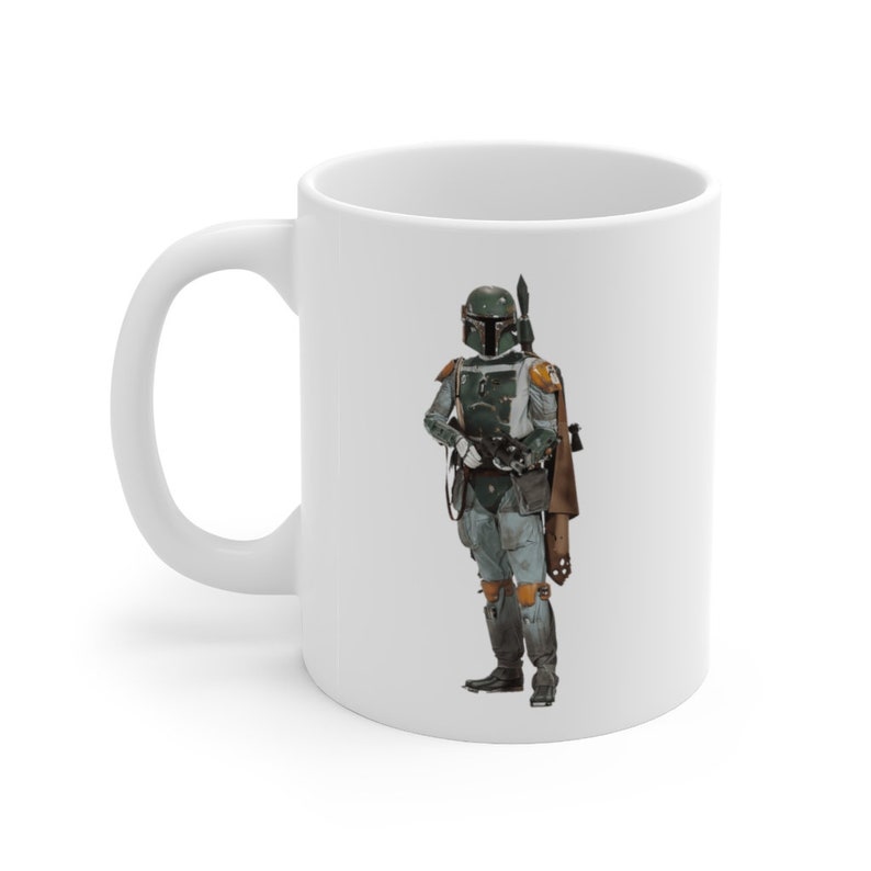May include: White ceramic mug with a green and brown image of a Star Wars character, Boba Fett, wearing a helmet and holding a blaster.