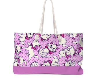May include: A pink and white tote bag with a repeating pattern of white kittens wearing pink bows on a pink polka dot background. The bag has white rope handles.