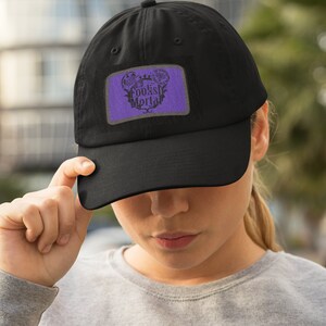 May include: A black baseball cap with a purple patch featuring a skull and the text "Foolish Mortal".