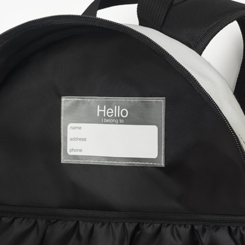 May include: Black backpack with a clear plastic name tag that says "Hello I belong to" with spaces for name, address, and phone number.