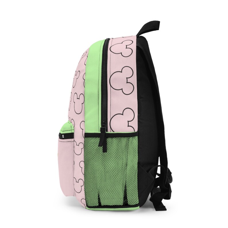 May include: A pink and green backpack with a black zipper and a pattern of black Mickey Mouse heads. The backpack has a mesh pocket on the side.