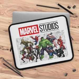May include: White laptop sleeve with a black zipper. The sleeve features a red and black Marvel Studios logo with a comic book style image of various Marvel characters including Hulk, Iron Man, Spider-Man, and Captain America.