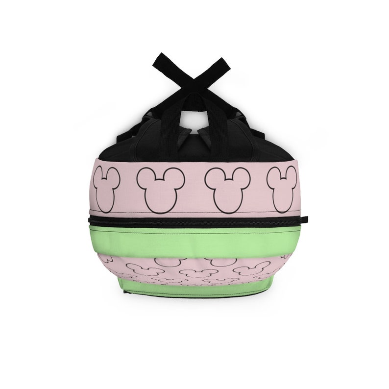May include: A black, green, and pink backpack with a repeating pattern of Mickey Mouse ears. The backpack has a black zipper and adjustable straps.