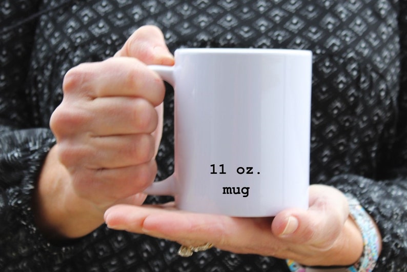 May include: White ceramic mug with a black inscription that reads "11 oz. mug".