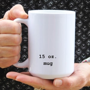 May include: White ceramic mug with a black inscription that reads "15 oz. mug".