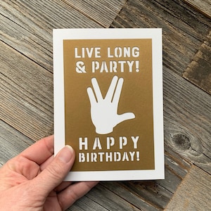 May include: A gold card with the text "Live Long & Party!" and a white silhouette of the Vulcan salute. Below the salute is the text "Happy Birthday!"
