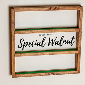 May include: A wooden wall shelf with three shelves. The shelves are lined with green felt. The shelf has the text "Green Felt & Special Walnut" printed on the front.