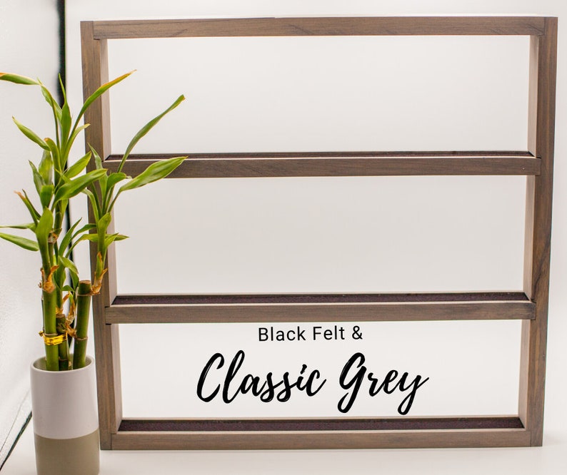 May include: A three-tiered wooden shelf with black felt lining. The shelf is labeled "Black Felt & Classic Grey".