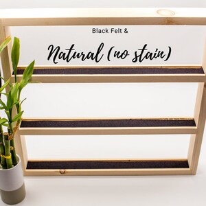 May include: A wooden shelf unit with three shelves, each lined with black felt. The shelves are natural wood with no stain. The text "Black Felt & Natural (no stain)" is printed on the top shelf.