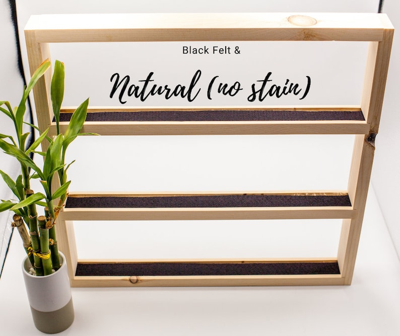 May include: A wooden shelf unit with three shelves, each lined with black felt. The shelves are natural wood with no stain. The text "Black Felt & Natural (no stain)" is printed on the top shelf.