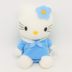 May include: A white plush toy with a blue sailor dress and a blue flower on its head. The toy has a key wind-up mechanism on its side.