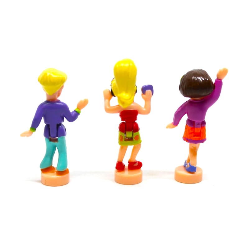 Puede incluir: Tres figuritas de pl&aacute;stico de personas bailando. Las figuras llevan ropa colorida y est&aacute;n posadas de forma din&aacute;mica. Las figuras est&aacute;n sobre un fondo blanco.