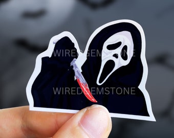 May include: A black and white sticker of a figure wearing a ghost face mask holding a bloody knife. The sticker has the text "Wiredgemstone" on it.