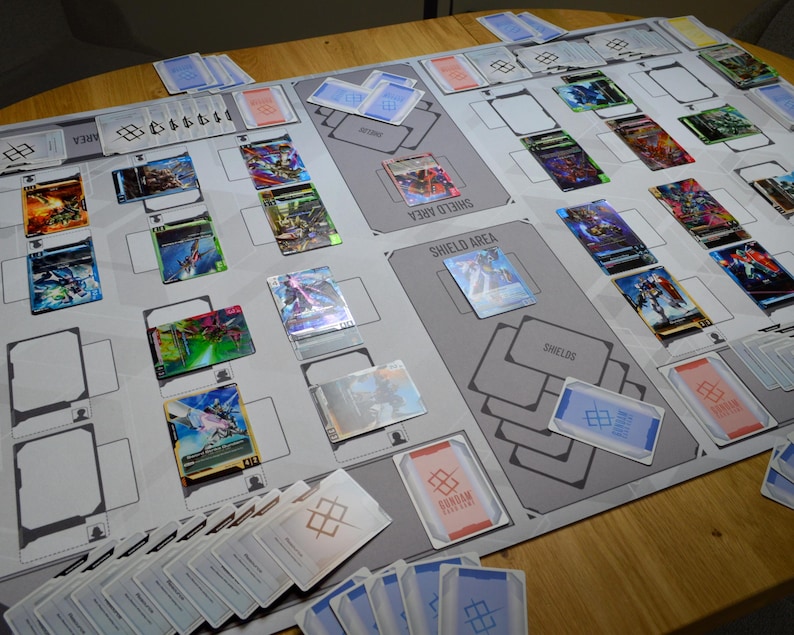 May include: A tabletop game setup featuring a playmat with designated areas for cards. Various colorful trading cards are arranged on the mat, along with stacks of cards and card sleeves. The game appears to be in progress.