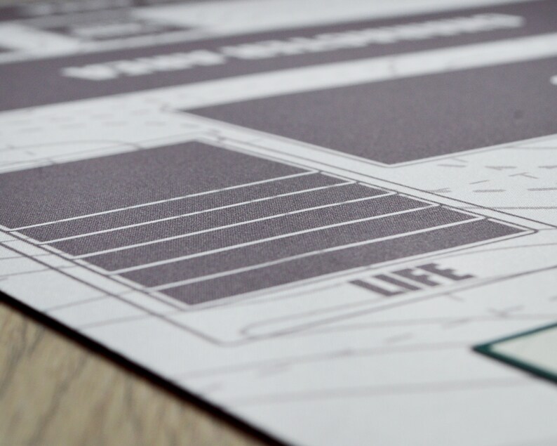 K&ouml;nnte beinhalten: Nahaufnahme einer gedruckten Grafik mit einem rasterartigen Design. Das Bild zeigt eine graue rechteckige Form mit horizontalen wei&szlig;en Linien, und das Wort "LIFE" ist sichtbar. Der Hintergrund ist hellgrau mit schwachen Linien.