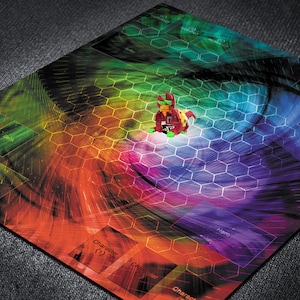 May include: A colorful game board with a hexagonal pattern and a central figure. The board features a vibrant spectrum of colors, including red, orange, yellow, green, and blue. The game piece is red and green. Text on the board reads "Character" and "Discard".