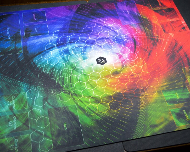 May include: A gaming playmat with a vibrant, rainbow-colored design. The mat features a hexagonal pattern and labeled zones for gameplay, including "Character," "Hero," and "Discard." The central area has a logo. The overall design is a blend of colors.