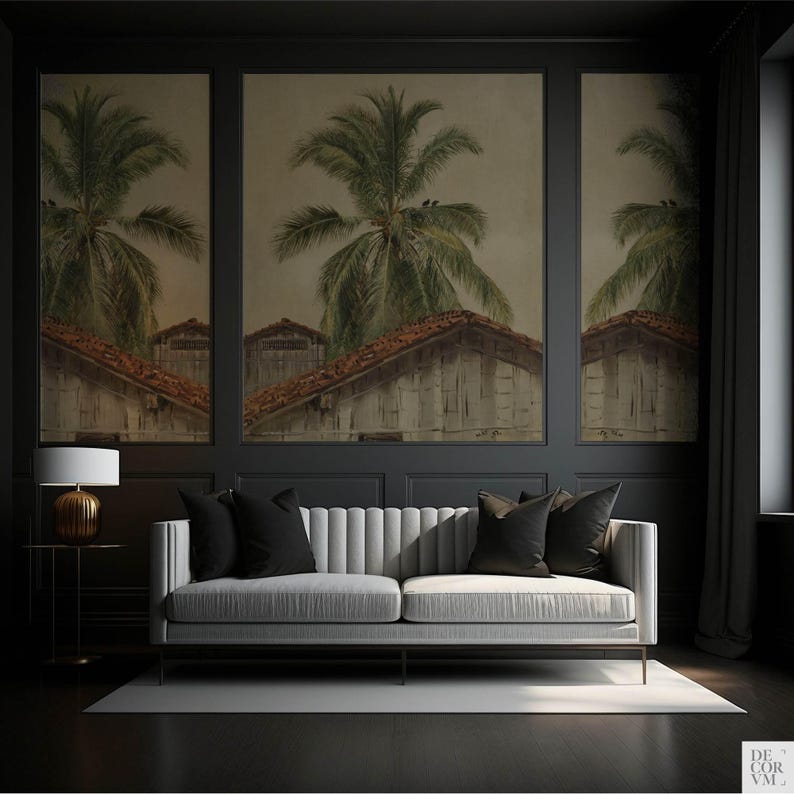 Puede incluir: Un sal&oacute;n con un sof&aacute; gris claro y cojines negros. La pared gris oscuro presenta tres obras de arte enmarcadas que representan palmeras y edificios. A la izquierda hay una peque&ntilde;a mesa auxiliar con una l&aacute;mpara.